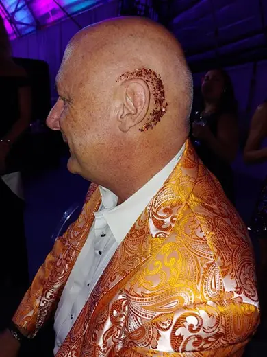 Henna design drawn around a guest's ear at a gala