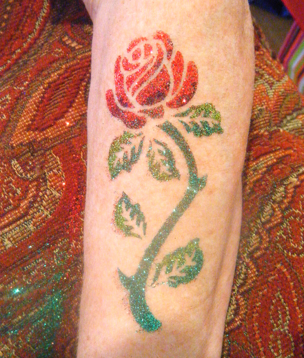 Red and green glitter rose on a forearm