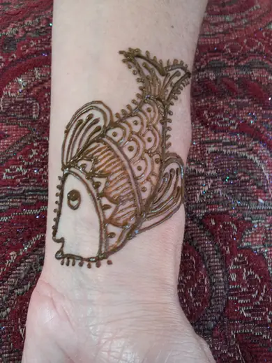 Playful henna fish design on the inside of a wrist