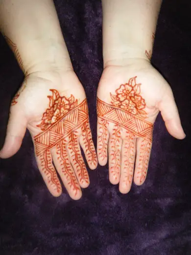 Two palms with henna flower and lace-stripe designs